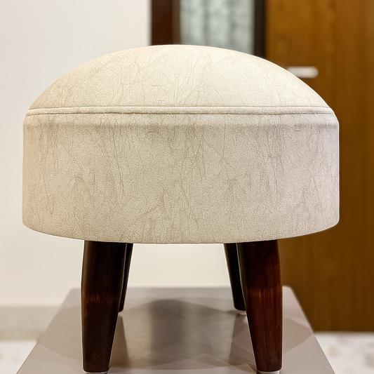 Ivory Silver round ottoman stool with dark wooden legs and subtle pearl texture