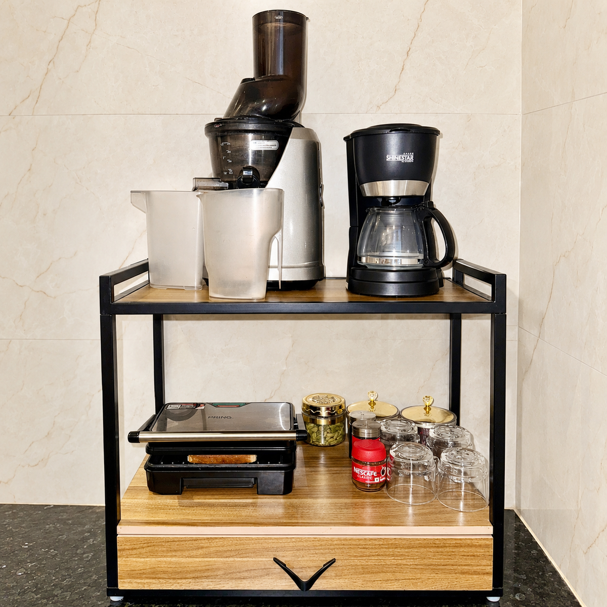 Sinecraft multipurpose kitchen rack arranged as a breakfast station with cold-press juicer, coffee maker, sandwich toaster, cups and storage drawer.